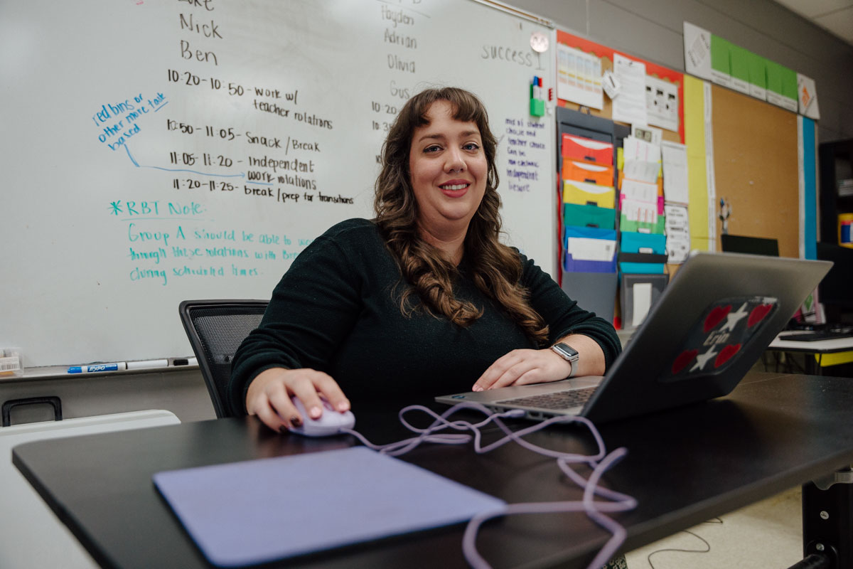 Erin Hennessy sitting in front of her computer at Quest Kids Academy